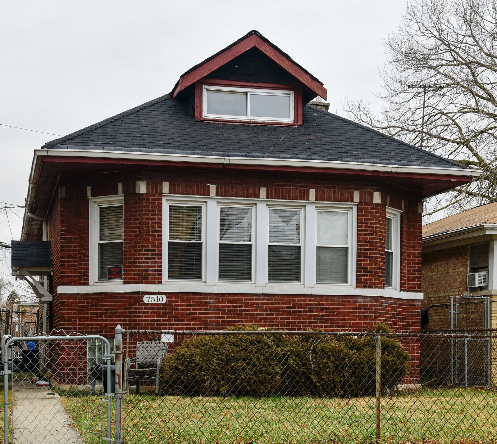 Brick Chicago bungalow with a dark asphalt roof and a front dormer